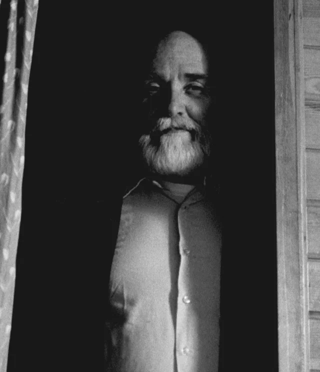 Father near end of life, seen in shadows through doorway